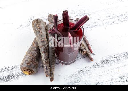 Traditioneller türkischer Getränkesaft (Salgam). Roter Karotten- und Rüssensaft auf weißem Holzhintergrund. Stockfoto