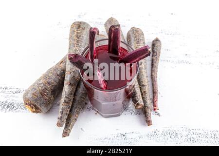 Traditioneller türkischer Getränkesaft (Salgam). Roter Karotten- und Rüssensaft auf weißem Holzhintergrund. Stockfoto