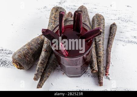 Traditioneller türkischer Getränkesaft (Salgam). Roter Karotten- und Rüssensaft auf weißem Holzhintergrund. Stockfoto