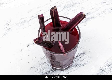 Traditioneller türkischer Getränkesaft (Salgam). Roter Karotten- und Rüssensaft auf weißem Holzhintergrund. Stockfoto