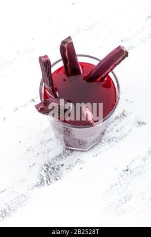 Traditioneller türkischer Getränkesaft (Salgam). Roter Karotten- und Rüssensaft auf weißem Holzhintergrund. Stockfoto