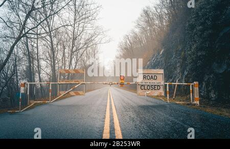 Leere, nebelige und nasse Straße mit Geschlossenem Schild Stockfoto