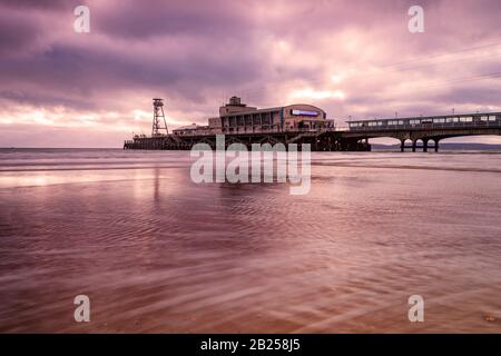 Der bunte Himmel über dem Bournemouth Pier spiegelt sich im Wasser wider Stockfoto