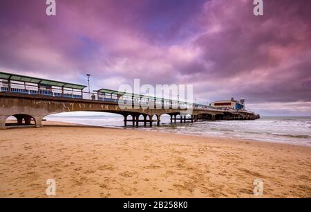 Der bunte Himmel über dem Bournemouth Pier spiegelt sich im Wasser wider Stockfoto