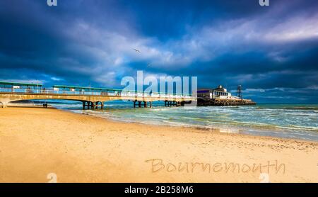 Der bunte Himmel über dem Bournemouth Pier spiegelt sich im Wasser wider Stockfoto