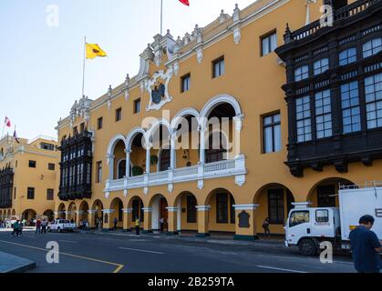 Lima/PERU - 10. Mai 2016: Die Vorderseite des Gemeindegebäudes in der Plaza Mayor de Armas mit Menschen und Fahrzeugen auf der Straße in Lima, Peru. Stockfoto