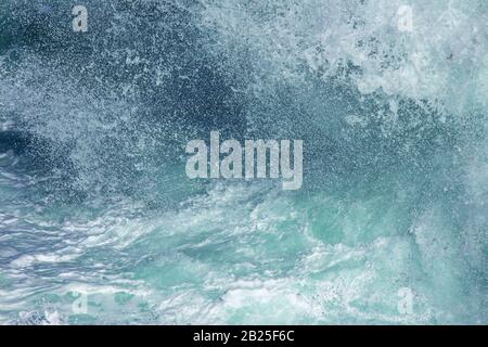 Aquatische Hintergrund der Meeresbrandung Wellen plätschern Nahaufnahme mit klarem, blauem Wasser und weißer Schaum Stockfoto