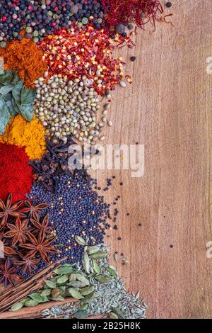 Aromatische Gewürze auf einem Holzbrett zur Seite des Rahmens Stockfoto