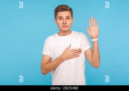 Ich schwöre! Portrait eines ehrlichen, aufrichtigen Mannes im T-Shirt, der mit der Hand aufs Herz verspreche, die Treue verpfände und das Gelübde mit verantwortungsbewußtem ernsten Gesicht gebe. I Stockfoto