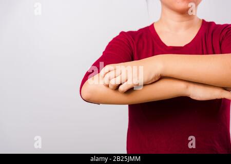 Die schöne asiatische Frau, die mit Copy-Space, Medical and Healthcare Concept ihren juckenden Arm auf weißem Hintergrund kratzt Stockfoto