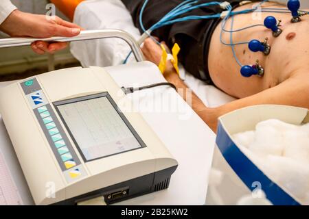 Kardiologe mit EKG-Geräte, Elektrokardiogramm Test des Patienten, der mit Vakuum Sensoren an der Maschine befestigt ist. Stockfoto