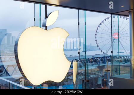 Apple Store Logo auf einer Glaswand, Nahaufnahme. Blick auf die Skyline der Stadt mit einem Riesenrad. Hongkong, 2018-03-14 Stockfoto