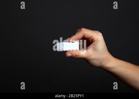 Flashlaufwerk in der Hand auf einem dunkelschwarzen Hintergrund. Geheime digitale Informationen. Stockfoto