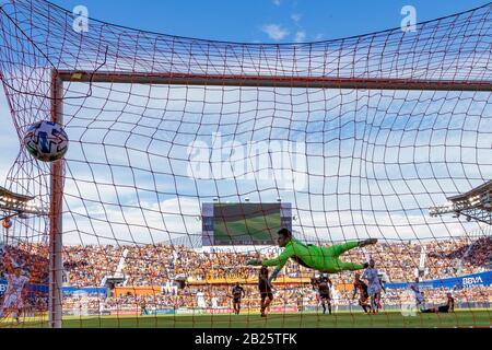 Houston, Texas, USA. Februar 2020. Los Angeles Galaxy Forward Cristian Pavon (10) nimmt den Schuss und punktet, als Houston Dynamo-Torhüter Marko Maric (1) für die Rettung aufspringt, aber der Ball ist gerade im BBVA Stadium in Houston, Texas, außer Reichweite. Maria Lysaker/CSM/Alamy Live News Stockfoto