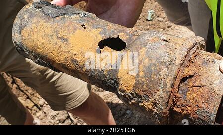 Trinkwasser-Rohre sind undicht und müssen repariert werden, großes Loch in der Leitung Stockfoto