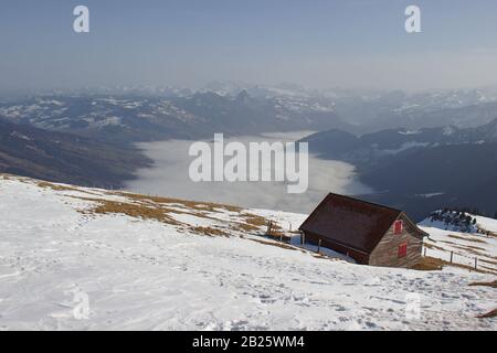 Kleine Hütte vor dem Tal voller Nebel Stockfoto