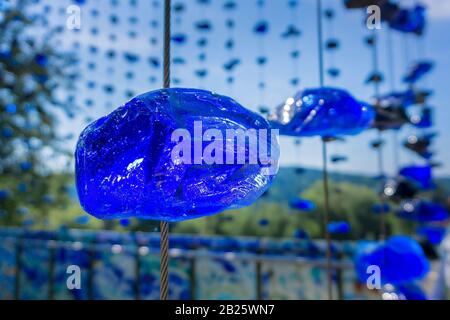 Ein zerbrochener Glasstein, der an einem Stahlkabel aufgehängt ist Stockfoto