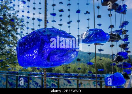 Ein zerbrochener Glasstein, der an einem Stahlkabel aufgehängt ist Stockfoto