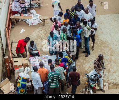 Die Leute hören auf, Zeitungen auf einem Zeitungsstand auf einer Straße in Lagos, Nigeria zu lesen. Stockfoto