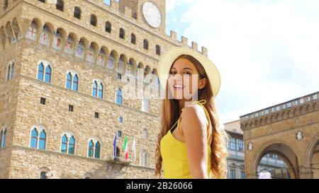 Schöne touristische Mädchen in Florenz mit Palazzo Vecchio Palast im Hintergrund. Panoramablick auf die Fahne Ansicht der jungen Frau in ihrem Urlaub in Italien. Stockfoto
