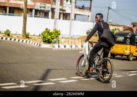 Ein Mann auf einem Fahrrad auf einer Straße in Lagos, Nigeria. Stockfoto