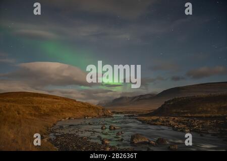 Aurora in Island Nordlichter leuchten grün und reflektieren im Fluss Stockfoto