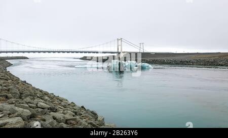 Joekulsarlon Glacier Lagoon tiefblaue Eisberge vor alter Hängebrücke Stockfoto