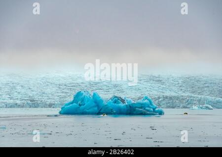 Motorboot Joekulsarlon Glacier Lagoon vor dem riesigen Eisberg in tiefblauer Farbe Stockfoto