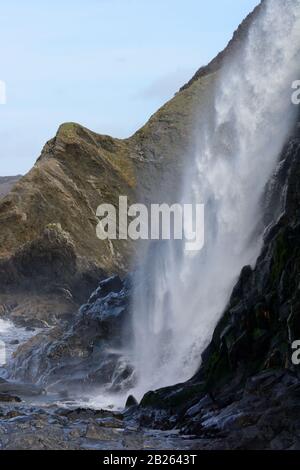 Wasserfall, der auf Tresaith Beach Ceredigion Wales Cymru UK einstürzt Stockfoto