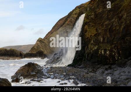 Wasserfall, der auf Tresaith Beach Ceredigion Wales Cymru UK einstürzt Stockfoto