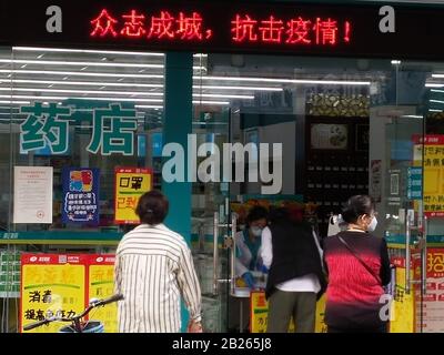 Shenzhen, China: Die Menschen warten darauf, Masken vor einer Apotheke zu kaufen Stockfoto