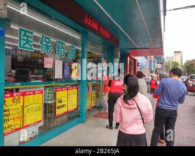 Shenzhen, China: Die Menschen warten darauf, Masken vor einer Apotheke zu kaufen Stockfoto