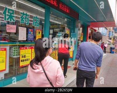 Shenzhen, China: Die Menschen warten darauf, Masken vor einer Apotheke zu kaufen Stockfoto