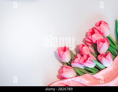 Rosa Blumen weißer Hintergrund. Blumenstrauß Rosen-Tulpen in der rechten unteren Ecke auf einem isolierten weißen Hintergrund. Flaches Lay Mock oben, Draufsicht Stockfoto