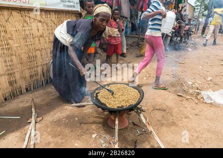 Braten von grünen, unreifen Kaffeebohnen auf einer flachen Pfanne bei einer Buna Wetten im Süden Äthiopiens Stockfoto