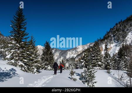 Zwei Männer Skitour durch das Vallée des Avals in der Nähe des französischen Alpenortes Courchevel nach frischem Schneefall an einem sonnigen Tag. Stockfoto
