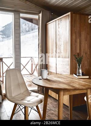 Kaffee auf dem Tisch mit wunderschönem Blick auf die Berge in der Winterzeit des Holzhauses Stockfoto