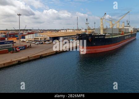 Das Frachtschiff Amis Wisdom 1 mit geöffneten Luken lädt Waren neben dem Quay in Port Gentil. Stockfoto