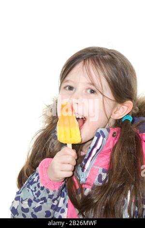 Junges Mädchen in der Winterjacke, das Eis ledig isst Stockfoto