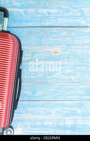 Rotes Kofferraumgepäck auf blauem Holztisch mit Kopierraum für den Hintergrund der Sommerferien Stockfoto