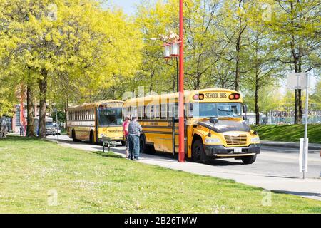 Vancouver - 05. Mai 2019: Downtown Vancouver, Kanada. Klassische gelbe Schulbusse parkten am Eingang von Chinatown, Vancouver, BC. Stockfoto