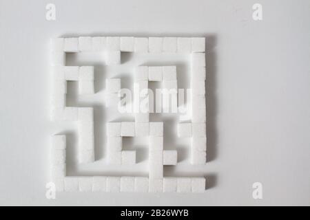 High Key Detail eines Labyrinths aus Zuckerwürfeln, die als Symbol für ungesunde Essgewohnheiten Stockfoto