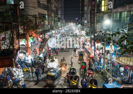 Viel Straßenverkehr mit Rikschas und Motorrädern in der Nacht in Dhaka, Bangladesch Stockfoto