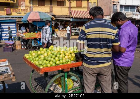 Mysore, Indien - 12. März 2018: Zwei Verkäufer, die Guava-Früchte auf einem externen Bauernmarkt in Mysore verkaufen, am Morgen eingenommen in Indien. Stockfoto