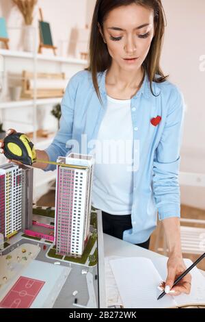 Kreativer Architekt, der ein neues Design für das Bauen, die Entwicklung der Nachbarschaft, die Nahaufnahme in vertikaler Richtung aufstellt. Stockfoto