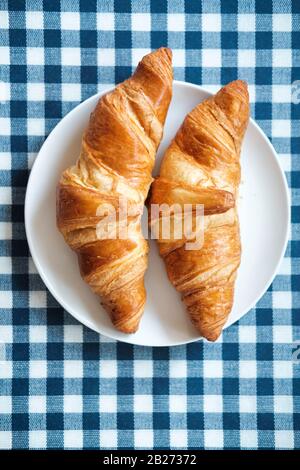 Zwei einfarbige Croissants auf einem weißen Teller - Draufsicht Stockfoto