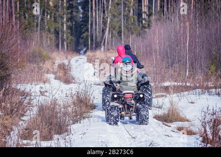 Familie auf der ATV Quad Bikes auf der Winterstraße. Stockfoto