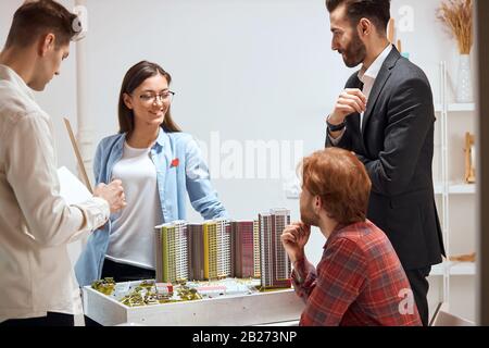 Designer genießen Arbeitsprozess am Arbeitsplatz. Nahaufnahme Foto. Positive Stimmung, atmospere im Büro, glückliche Frau, die ihre Pläne teilt, Werbeaktion Stockfoto