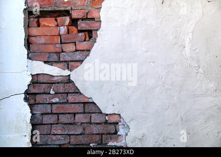 Eine schöne weiße, mit Stuck bemalte Wand mit freiliegenden roten Backsteinen aus Vintage-Rot Stockfoto