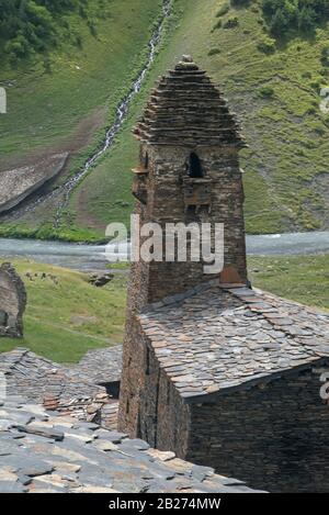 Defensive Tower (Dartlo) vor grünem Berghintergrund. Von oben ist zu sehen, dass alle Dächer aus Flachstein bestehen, was traditionell war Stockfoto